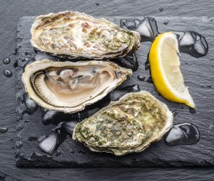 Raw oysters on the graphite board.